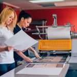 Deux jeunes femmes travaillant dans une imprimerie. Presse à imprimer